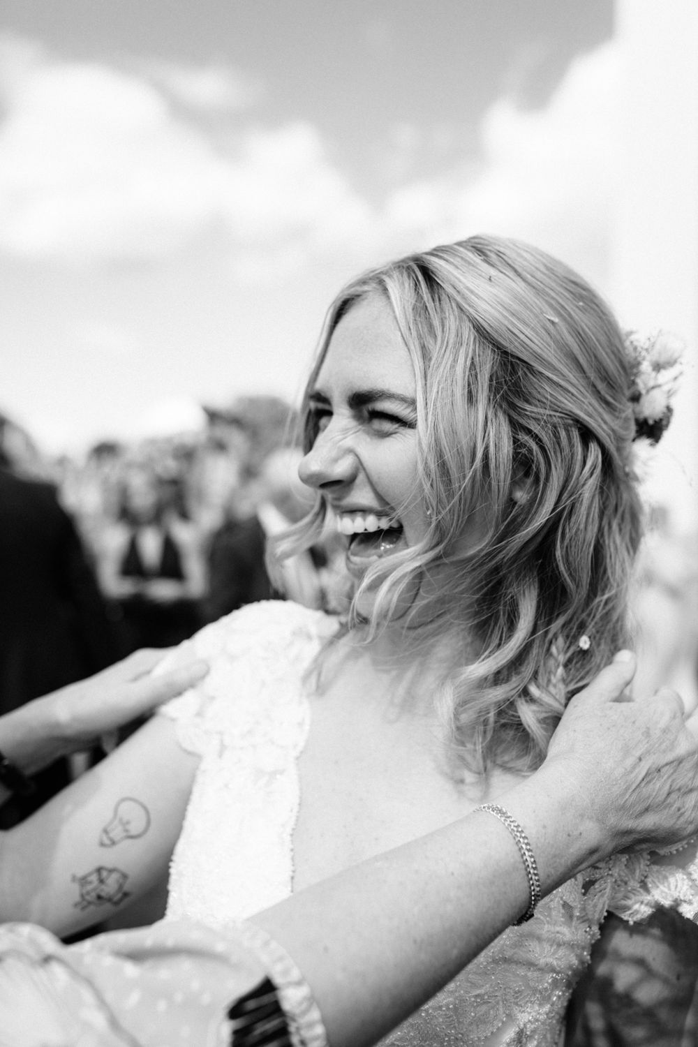 A candid black and white portrait capturing pure joy and laughter during a wedding celebration.