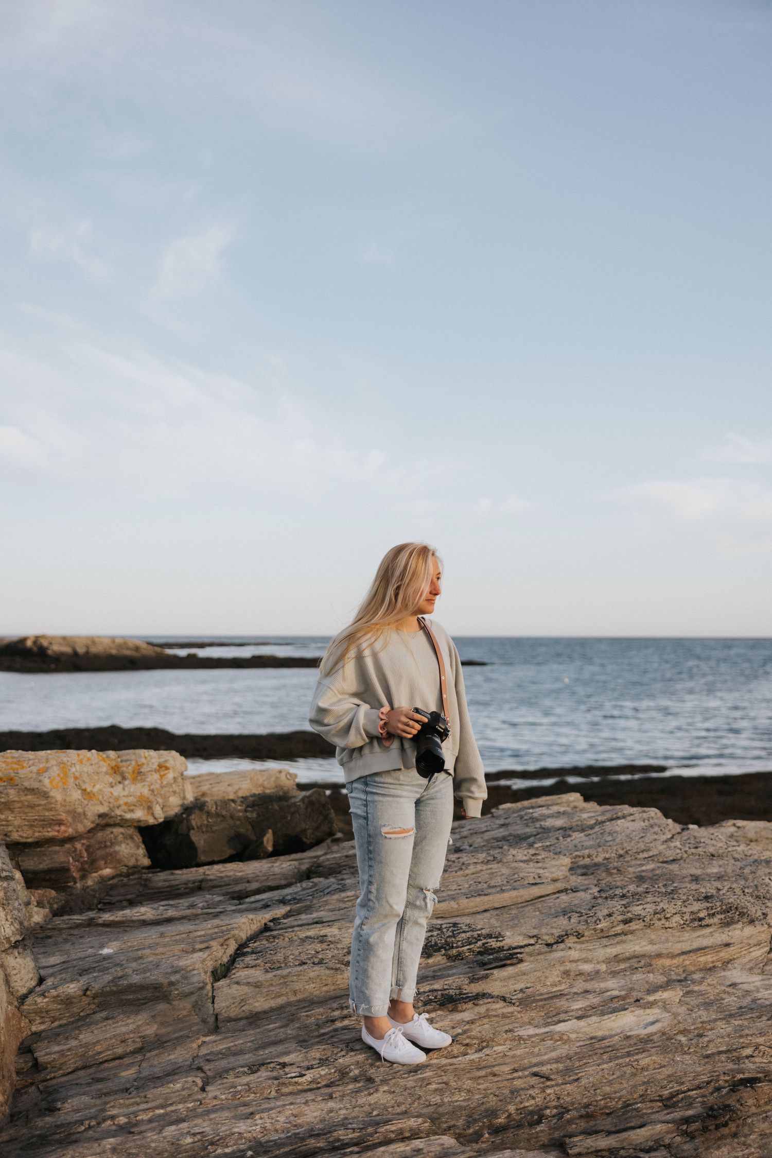 A coastal scene with rocky shoreline and ocean views on a bright sunny day.