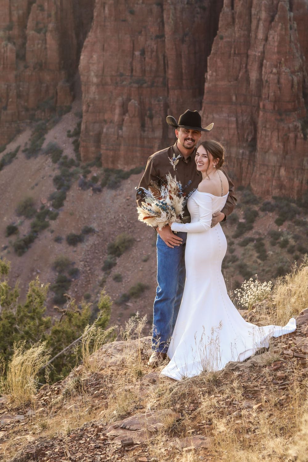 Portrait of a bride and groom embracing on a mountainside