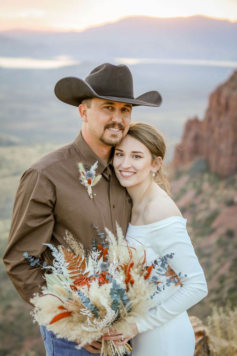 Portrait of a bride and groom embracing on a mountainside
