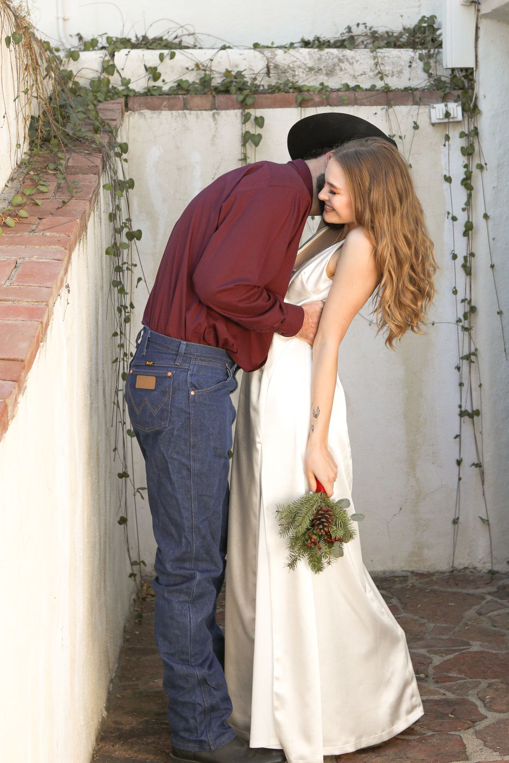 Portrait of a man kissing his smiling brides neck