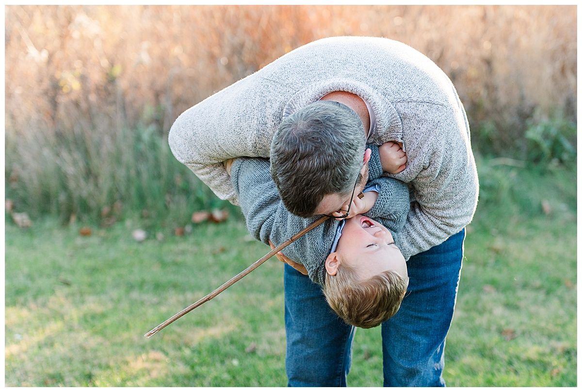 Candid photo of father and toddler son playing in Starkey Park Zionsville Indiana during autumn