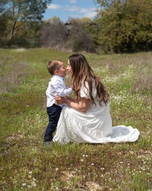 Tender moment between parent and child in a spring meadow with wildflowers.