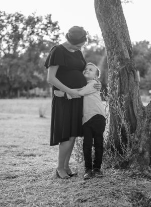 A touching black and white portrait of two people embracing by a tree.