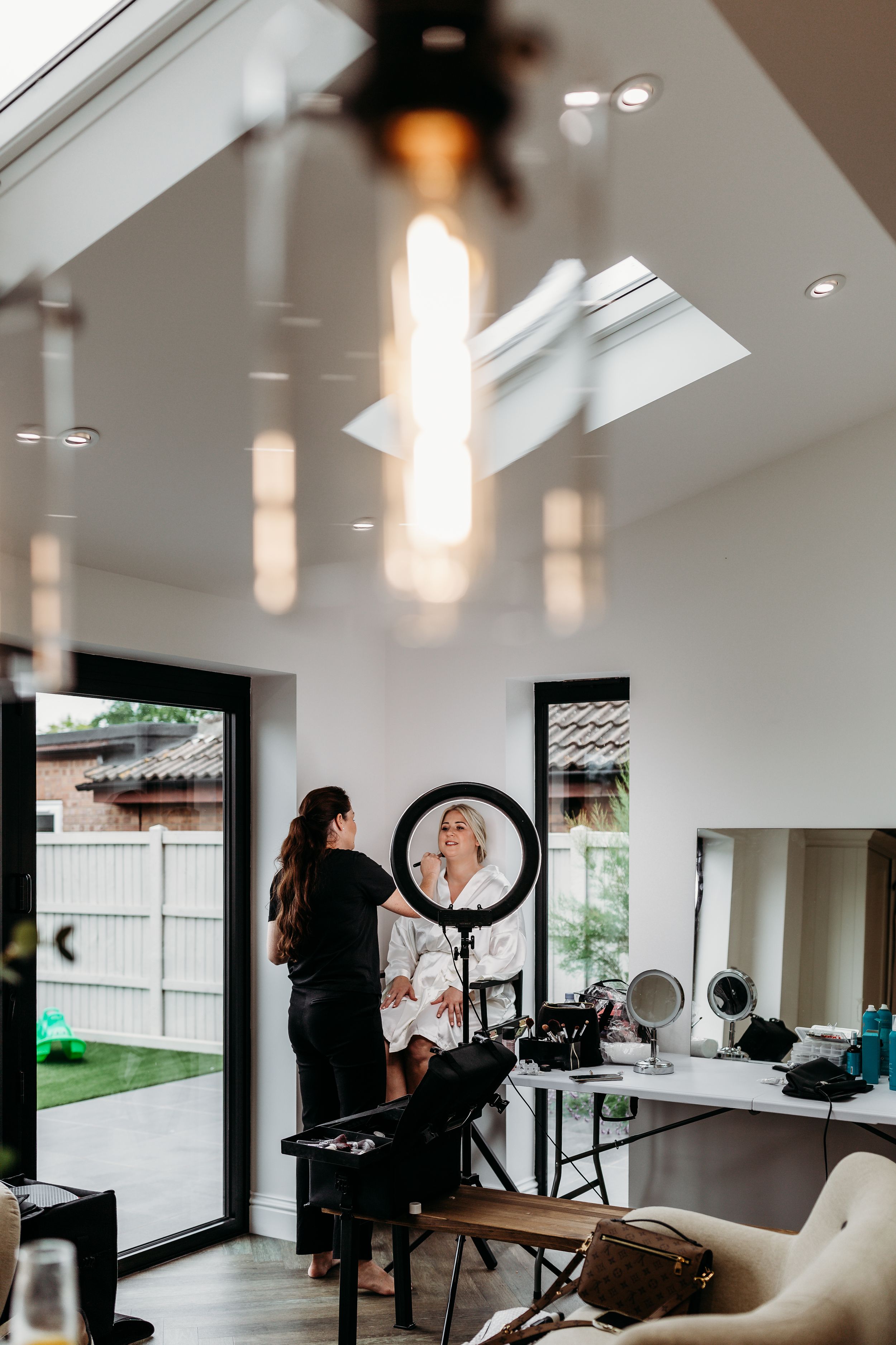 Modern makeup studio with skylights and ring lights for professional beauty services.