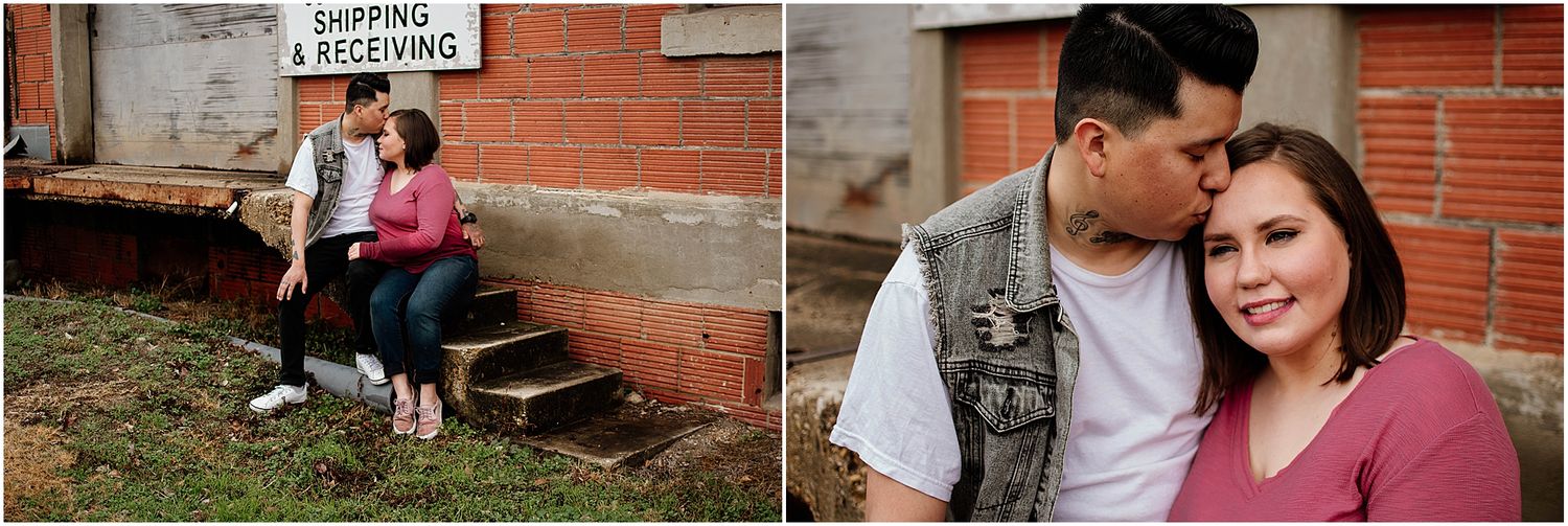 A couple sits on concrete steps next to a brick building.