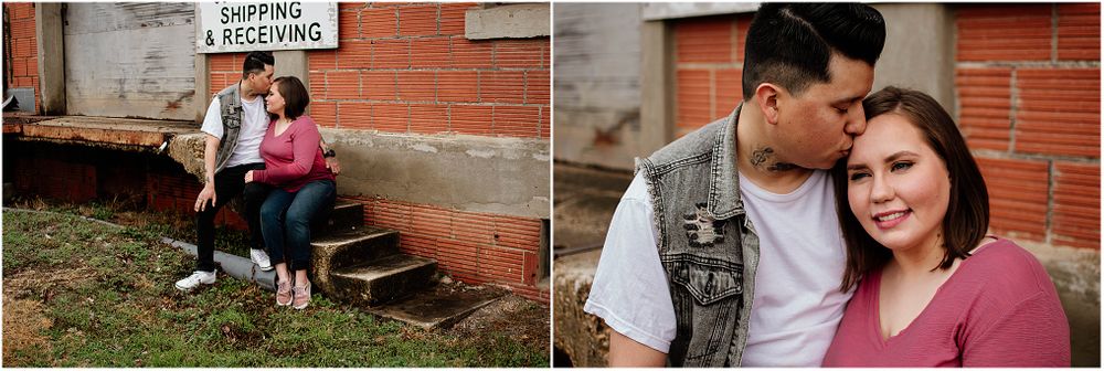 A couple sits on concrete steps next to a brick building.