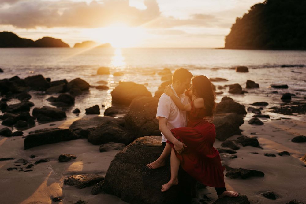 Engagement couple sitting on the beach at sunset in Costa Rica