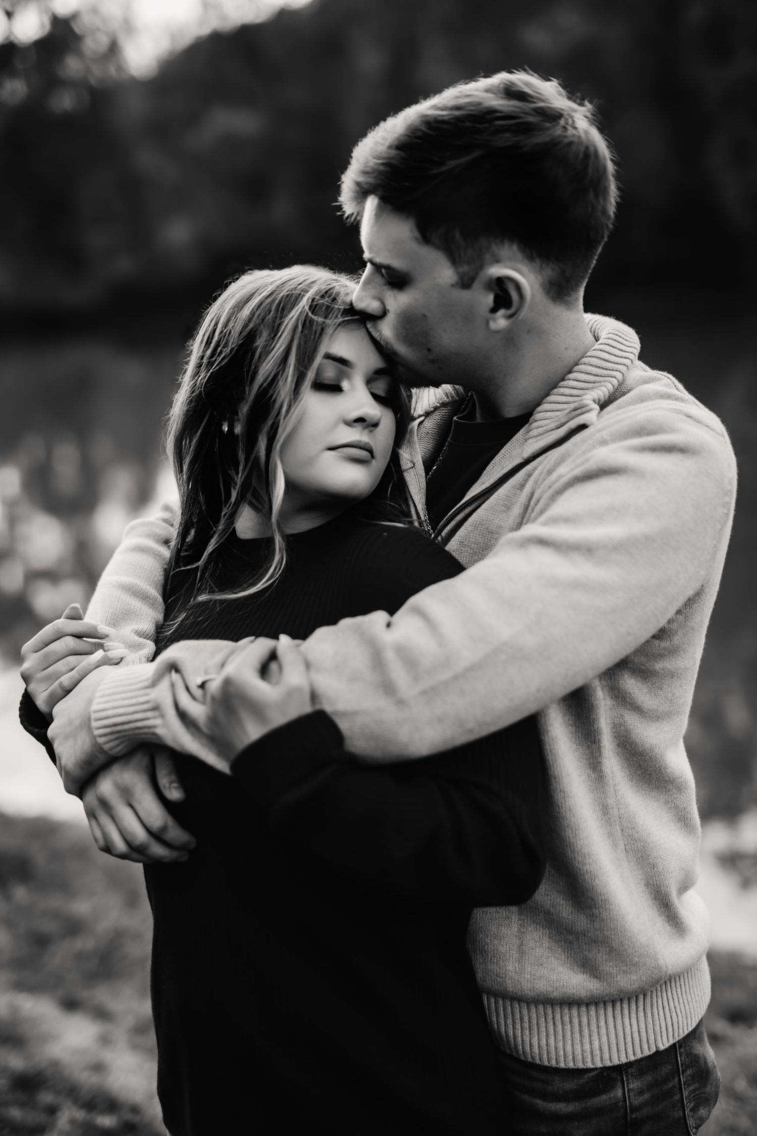 A romantic black and white photo sequence shows a couple sharing an intimate embrace outdoors.