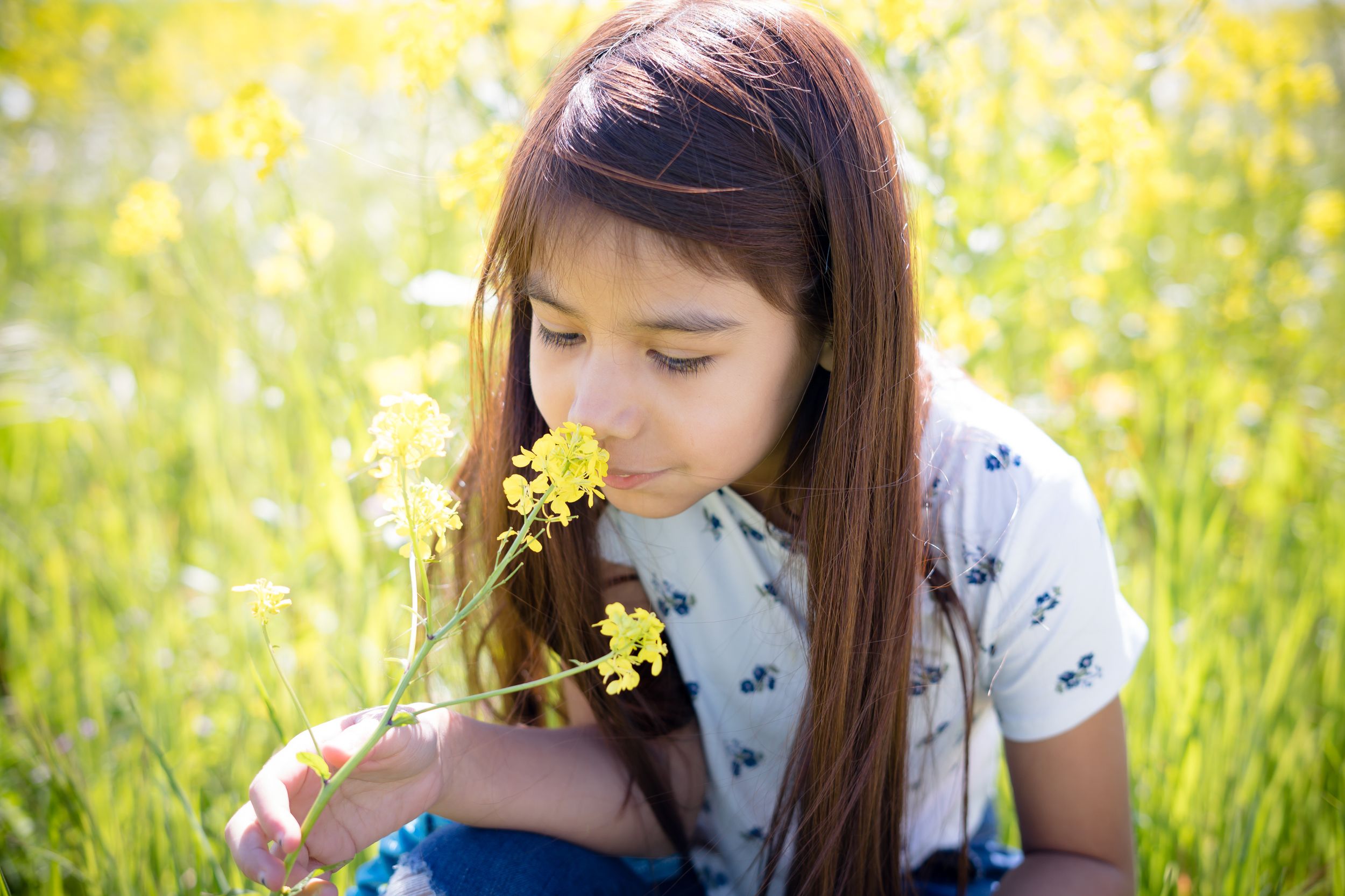 Sacramento portrait photographer - portrait of a young girl smelling flowers.