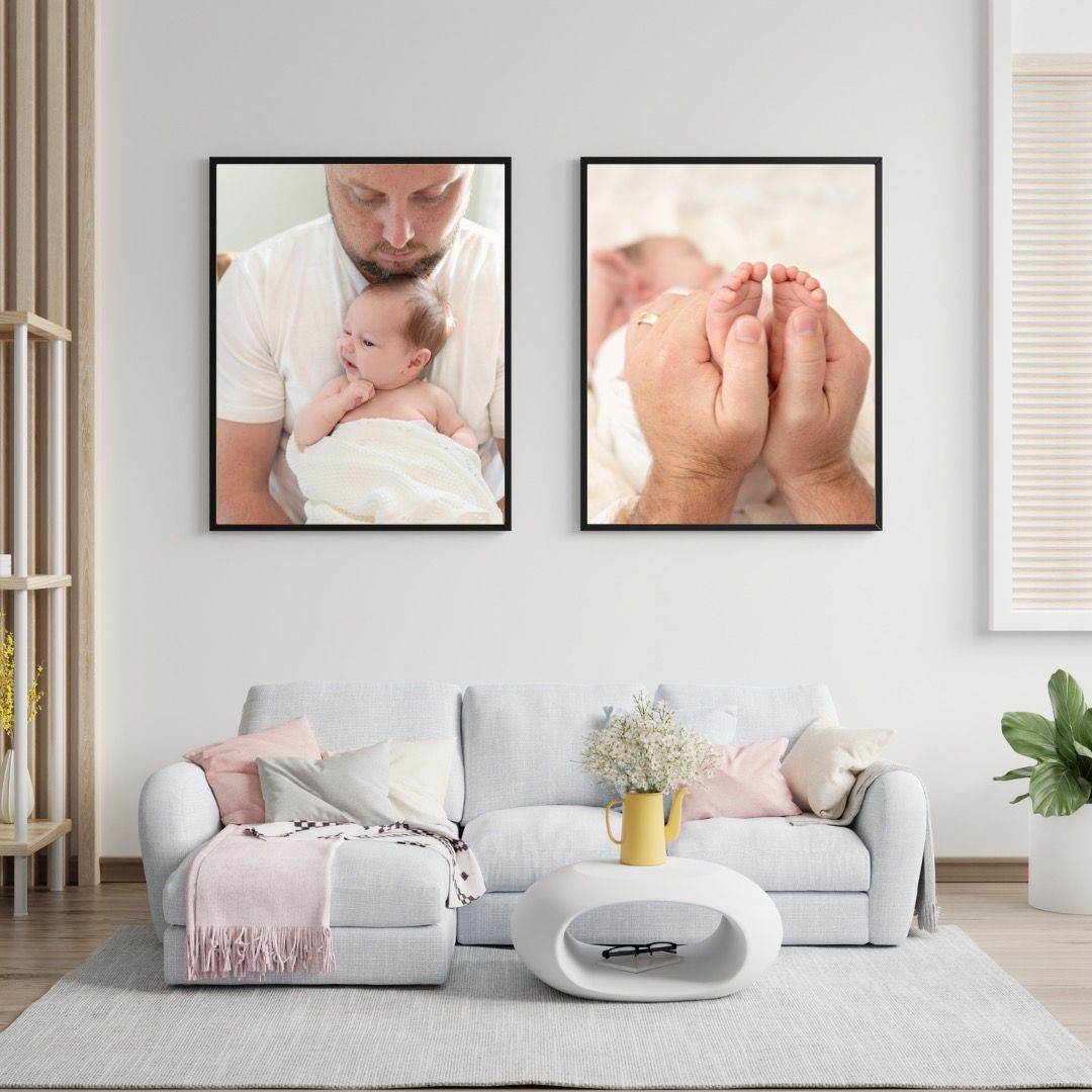 Two framed wall art prints featuring tender parent-child moments displayed above a modern gray sectional sofa in a living room.