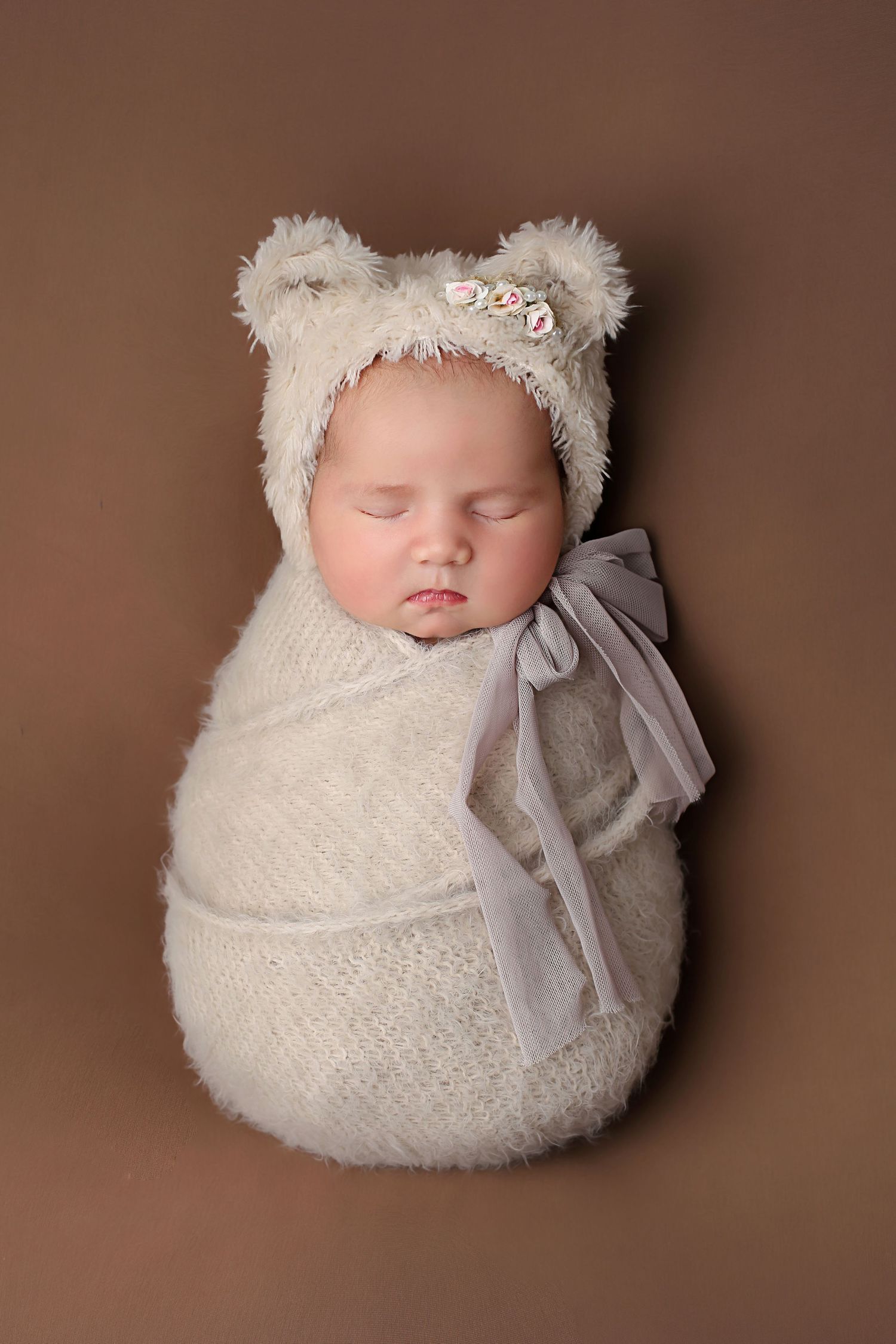newborn baby girl swaddled wrapped in a bear hat portrait photo