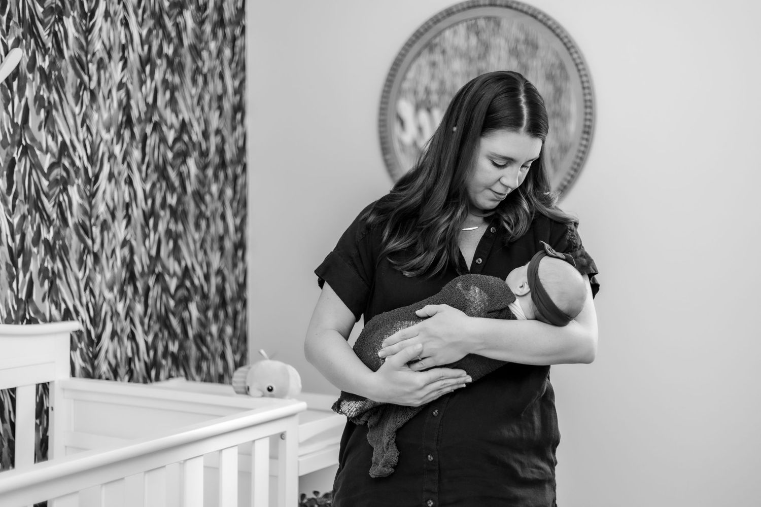 The mother glances adoringly at her baby.