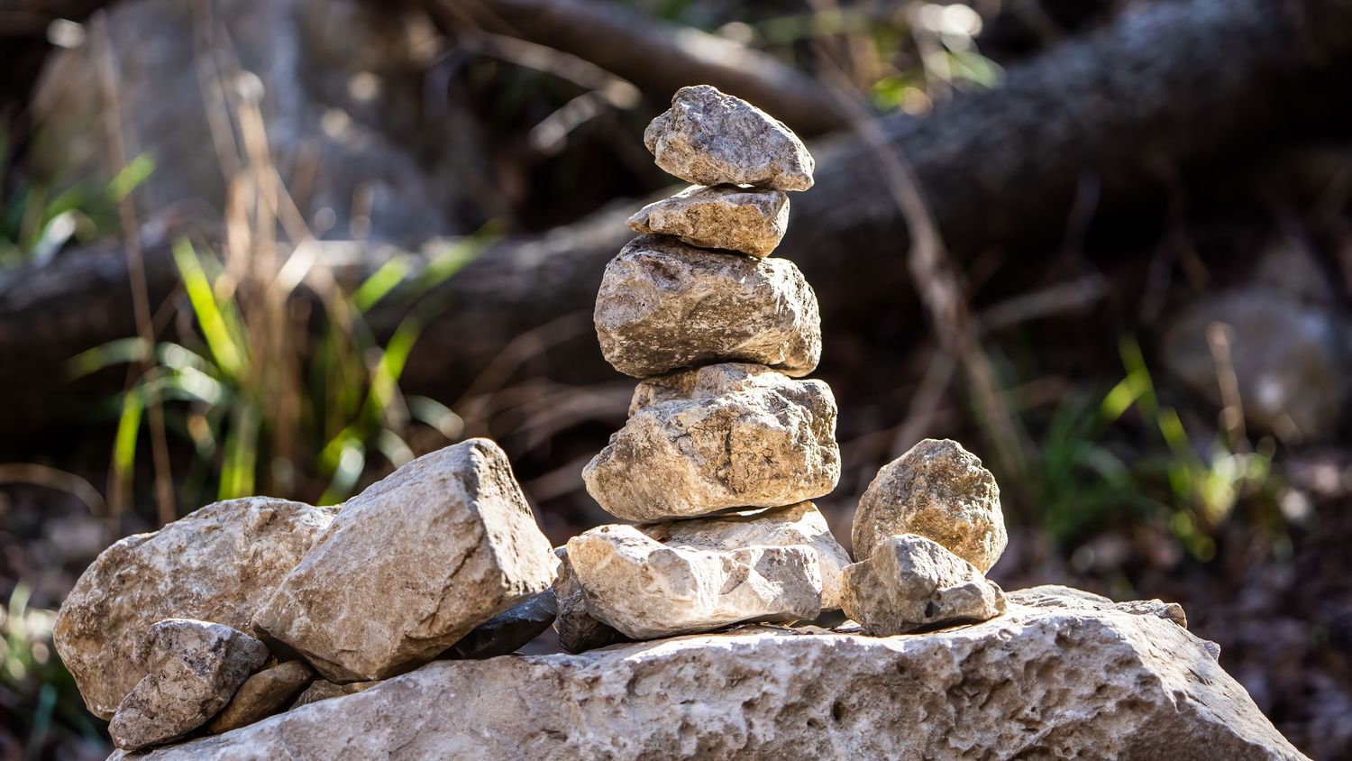 Stack of balanced rocks creating zen cairn against natural outdoor background.
