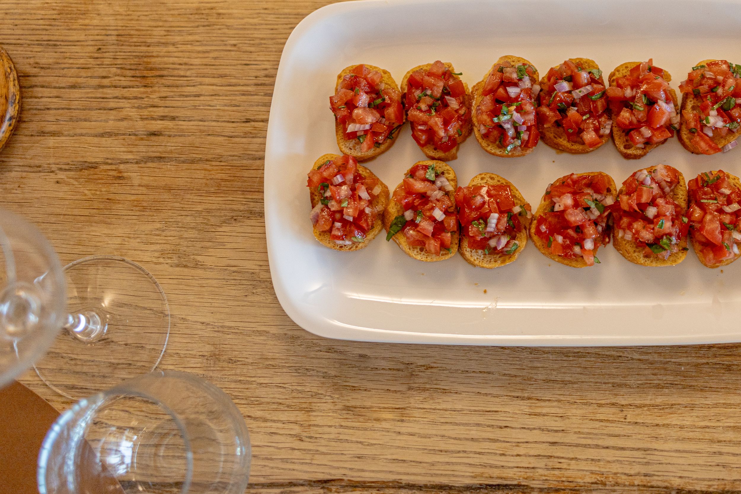 Row of appetizers beautifully plated on white serving platters.