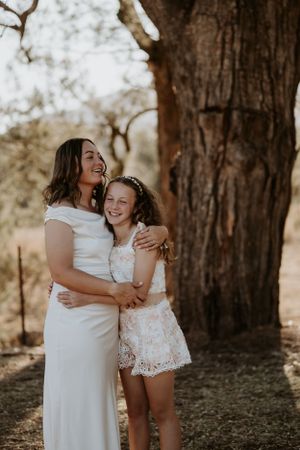 Candid family photos showing joyful embraces near large tree trunk.