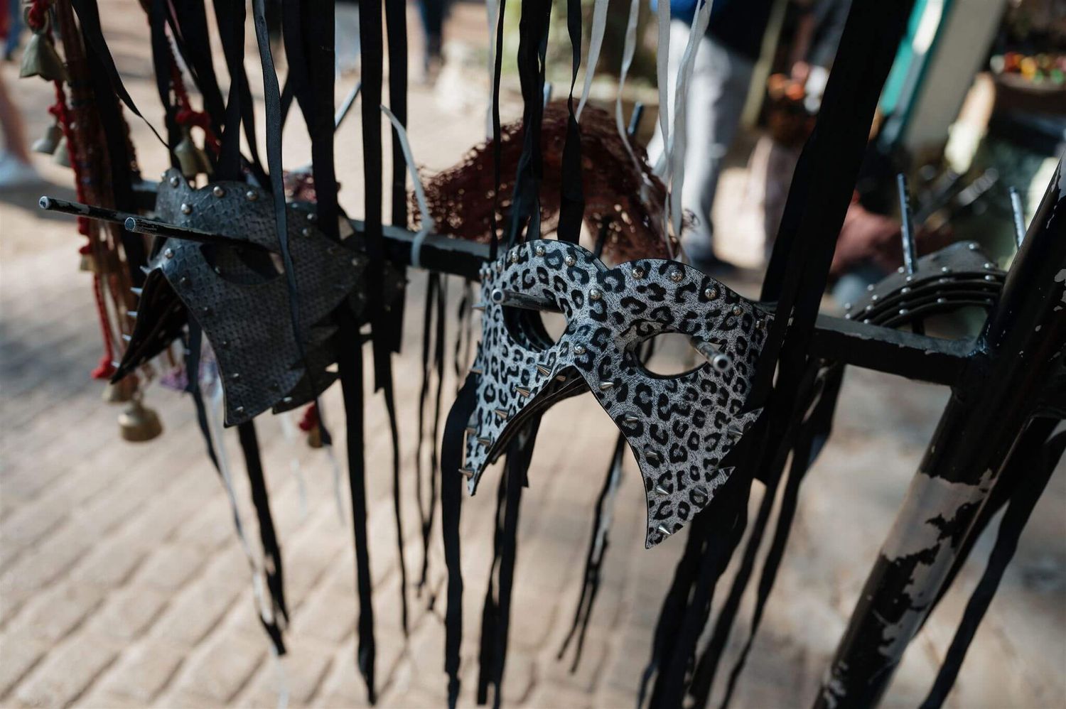 Ornate decorative masks with intricate designs hanging on display.