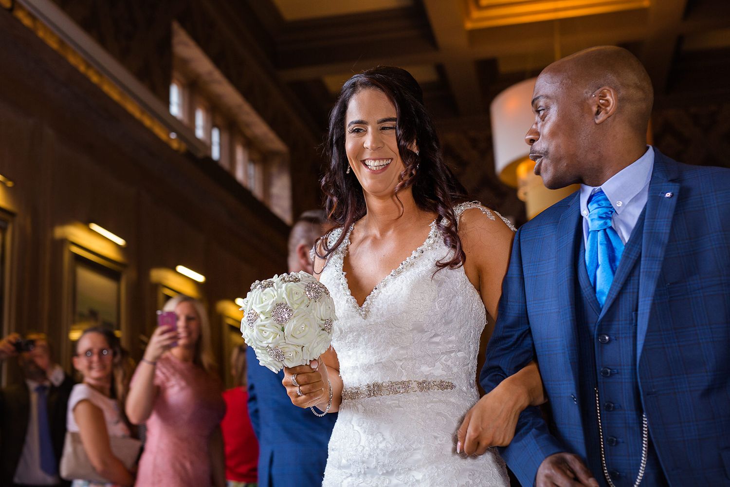 Bride and groom smile together as they exit their wedding ceremong at Abbey House in Cumbria