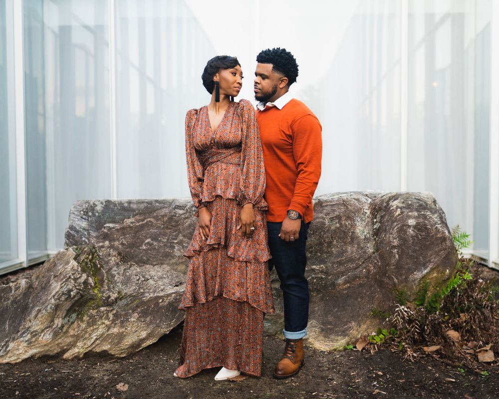 Couple in romantic pose among foggy white columns with woman in flowing dress.