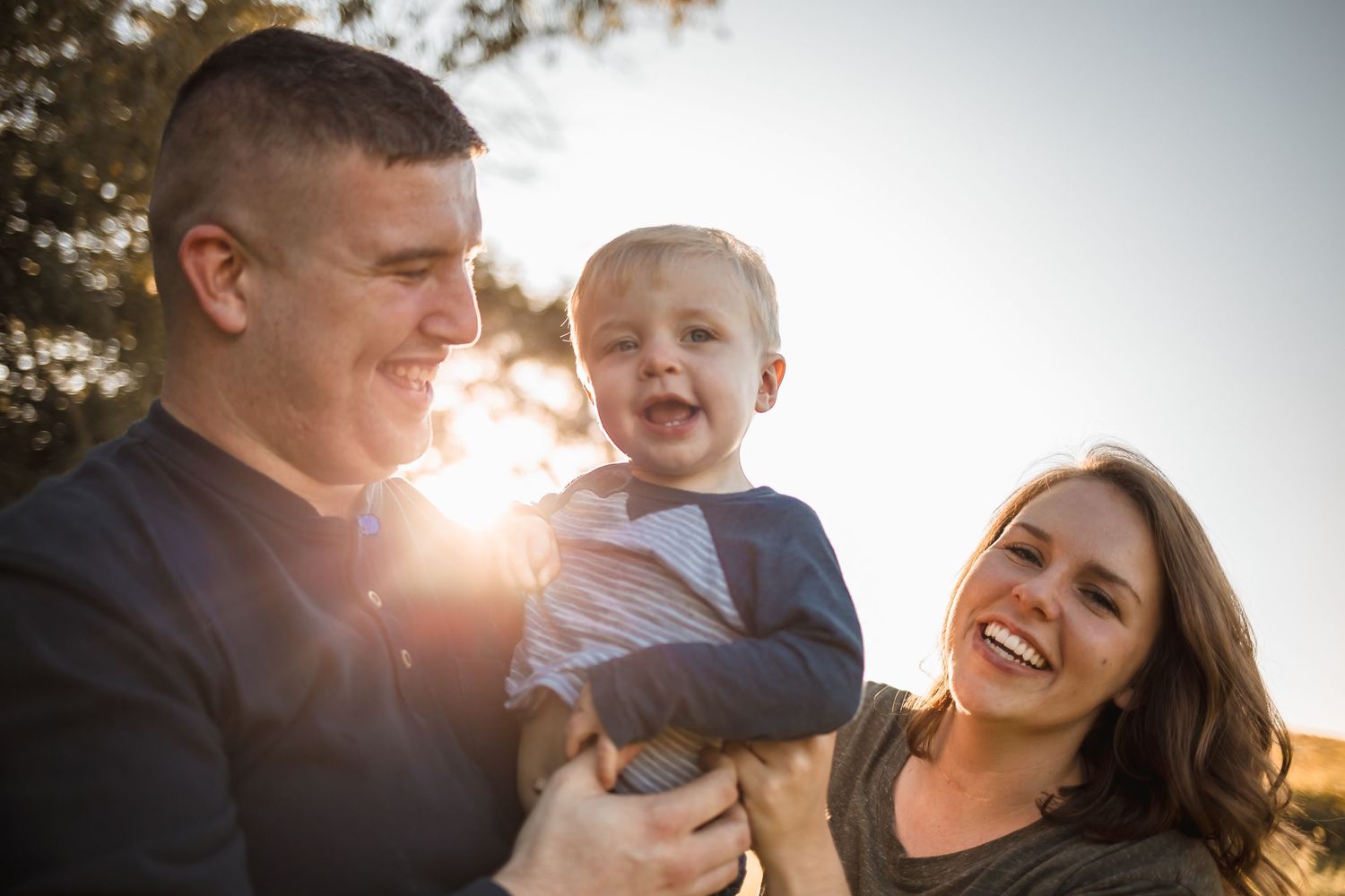 On Que Photography Dominique Renn Ohio Cincinnati Bethel FAMILY SMILING WITH TODDLER IN GORGEOUS SUNLIGHT OPEN FEILD