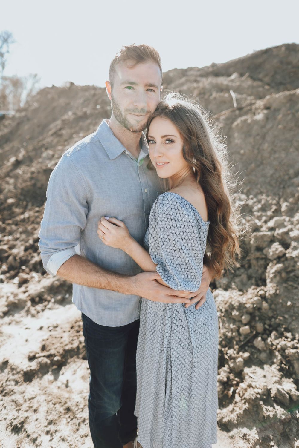 Intimate engagement portraits captured against rugged mountain backdrop with soft lighting.