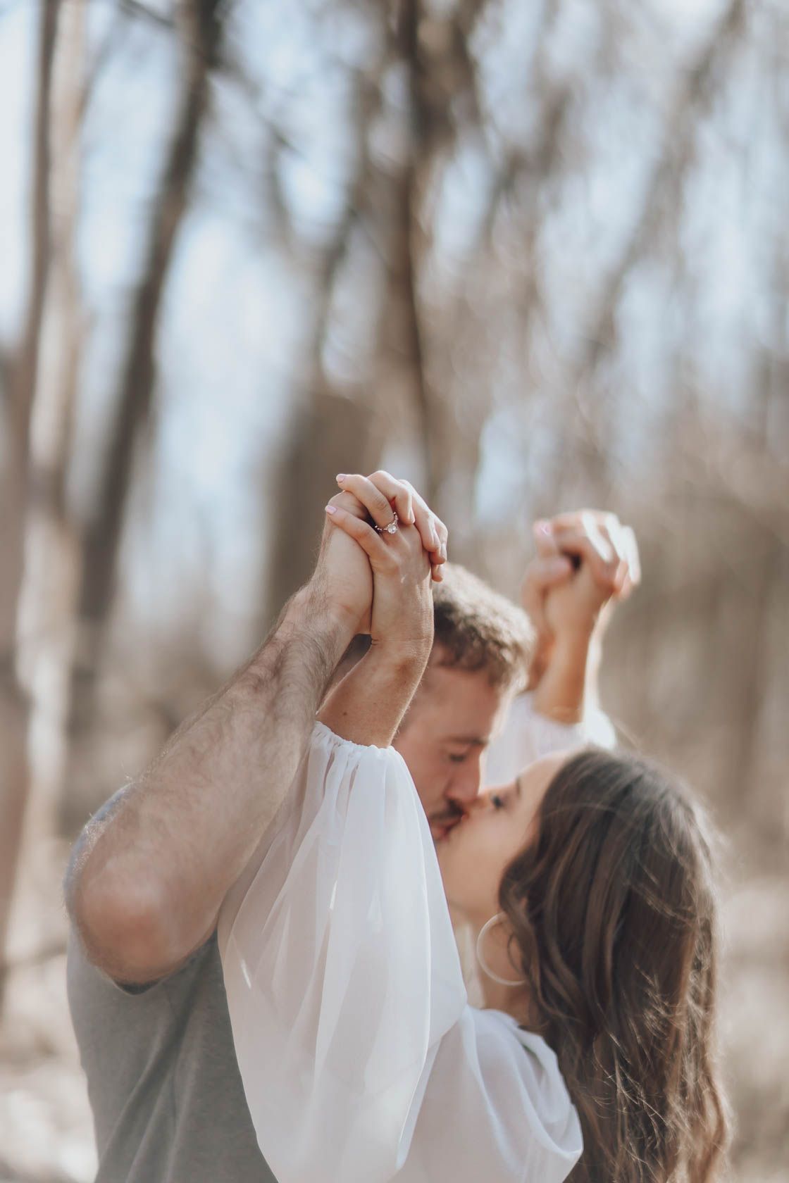 Dancing couple sharing romantic moments in a dreamy forest setting.