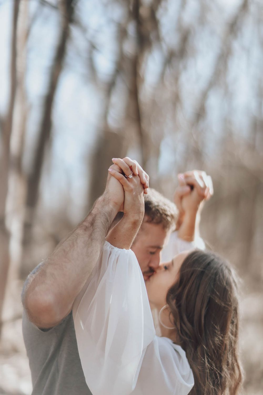 Dancing couple sharing romantic moments in a dreamy forest setting.