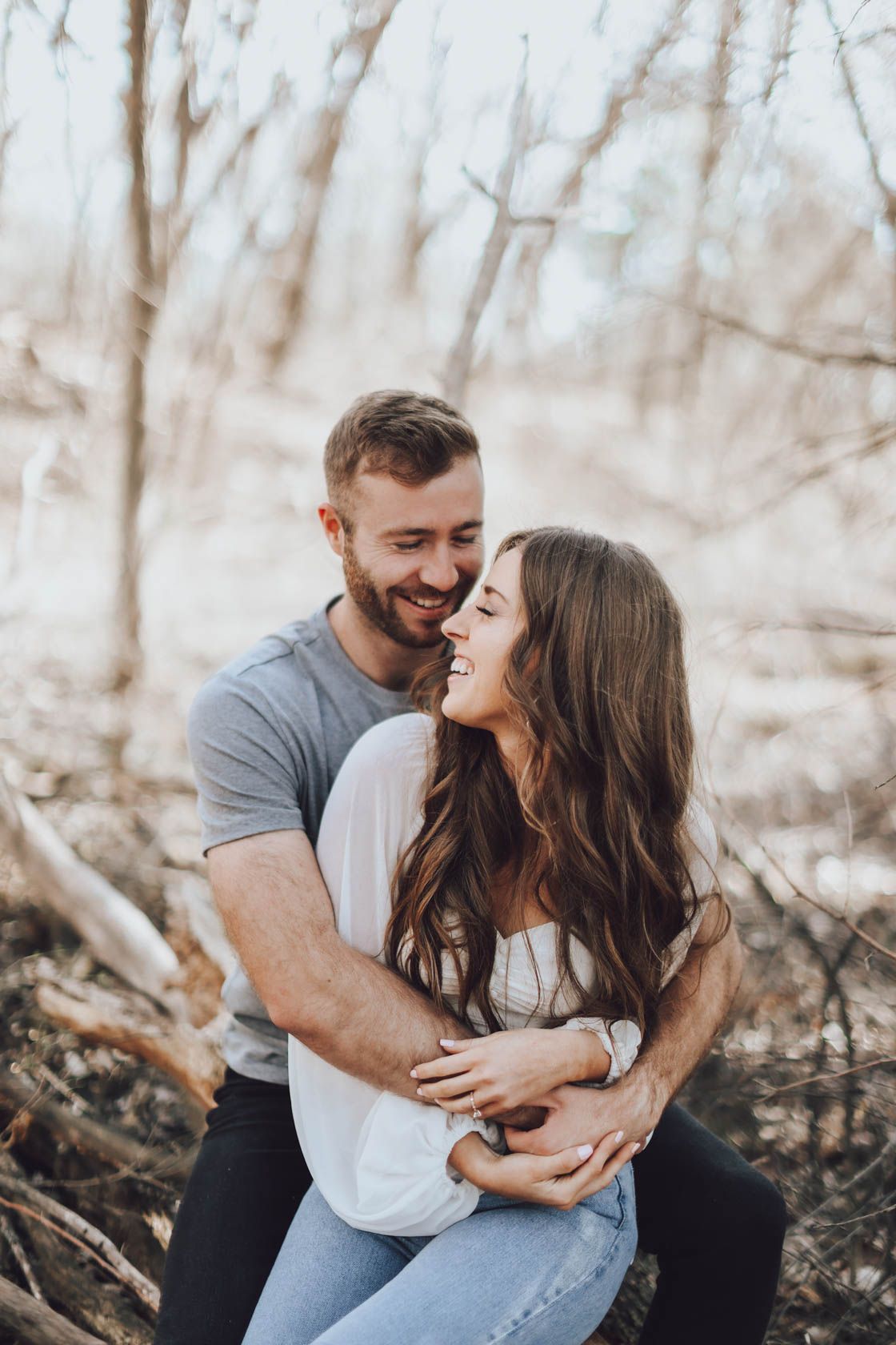 Intimate moments captured between couple during romantic forest photo session.