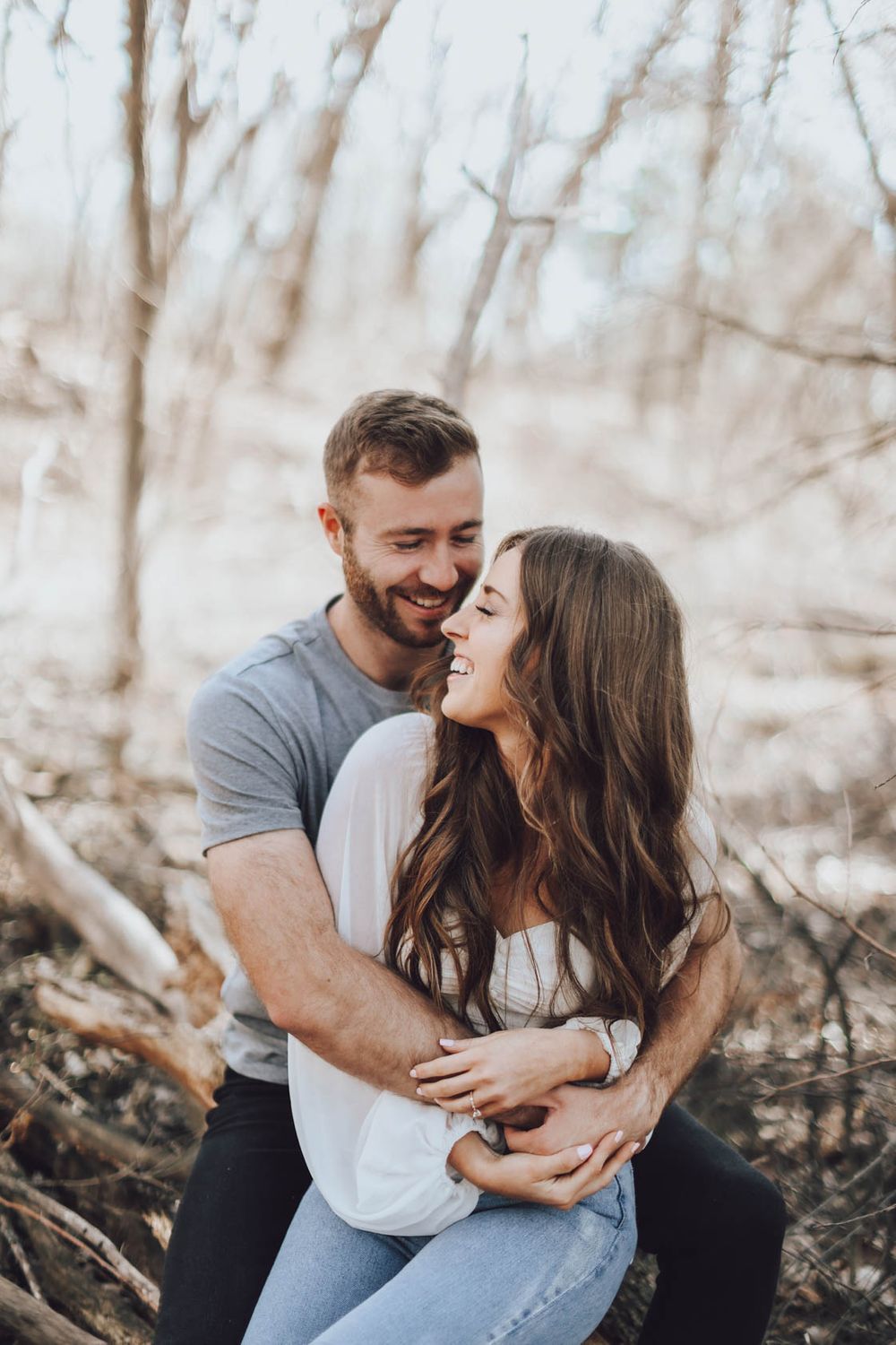 Intimate moments captured between couple during romantic forest photo session.