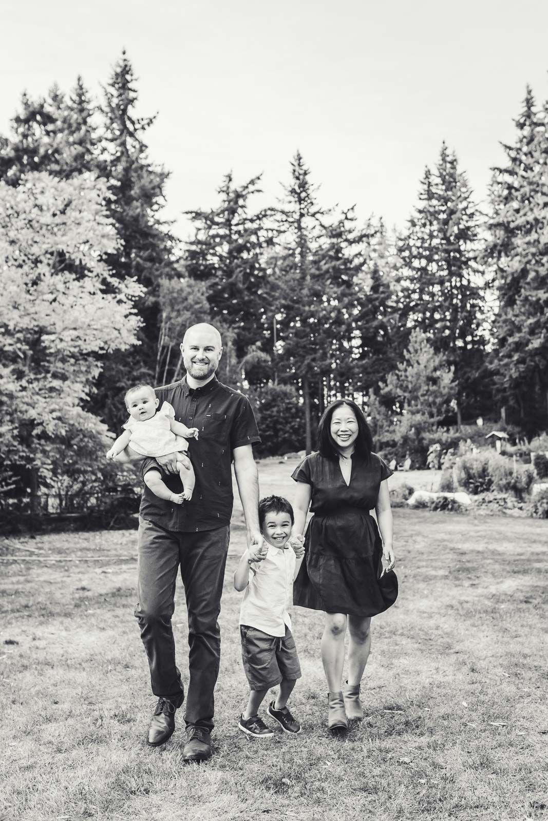 Black and white photo of family walking and laughing together