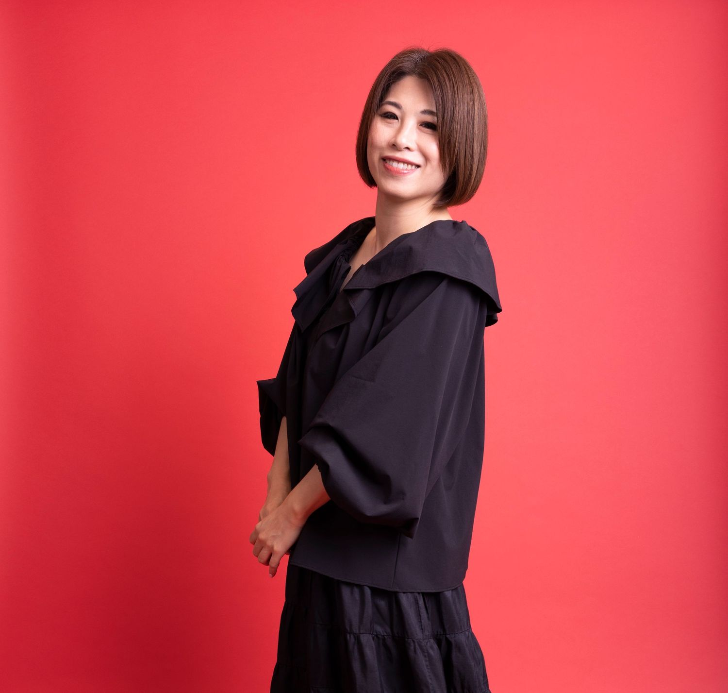 Asian woman with bob haircut wearing black ruffled blouse posing against vibrant red background.
ウェディングプランナー
ハワイウェディング
ハワイ挙式