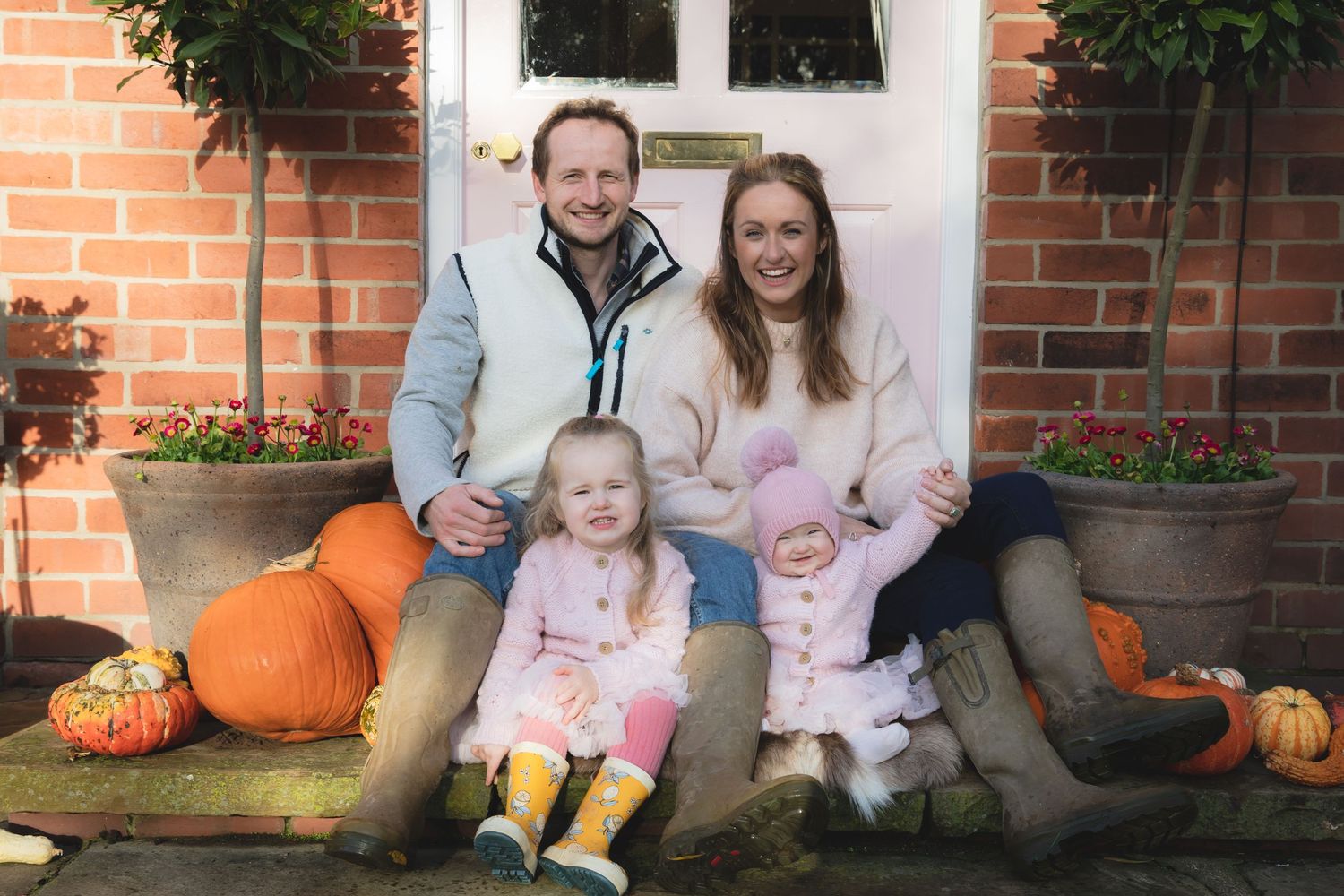 Fall family portrait session with pumpkins on brick porch steps.