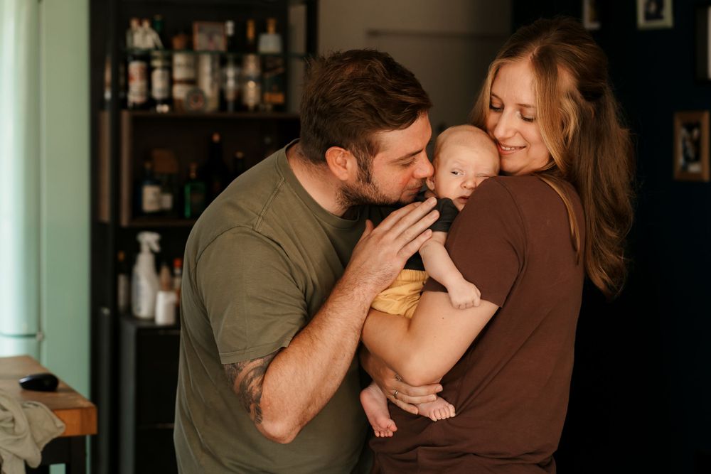 Intimate family moment captured in warm indoor lighting with baby.