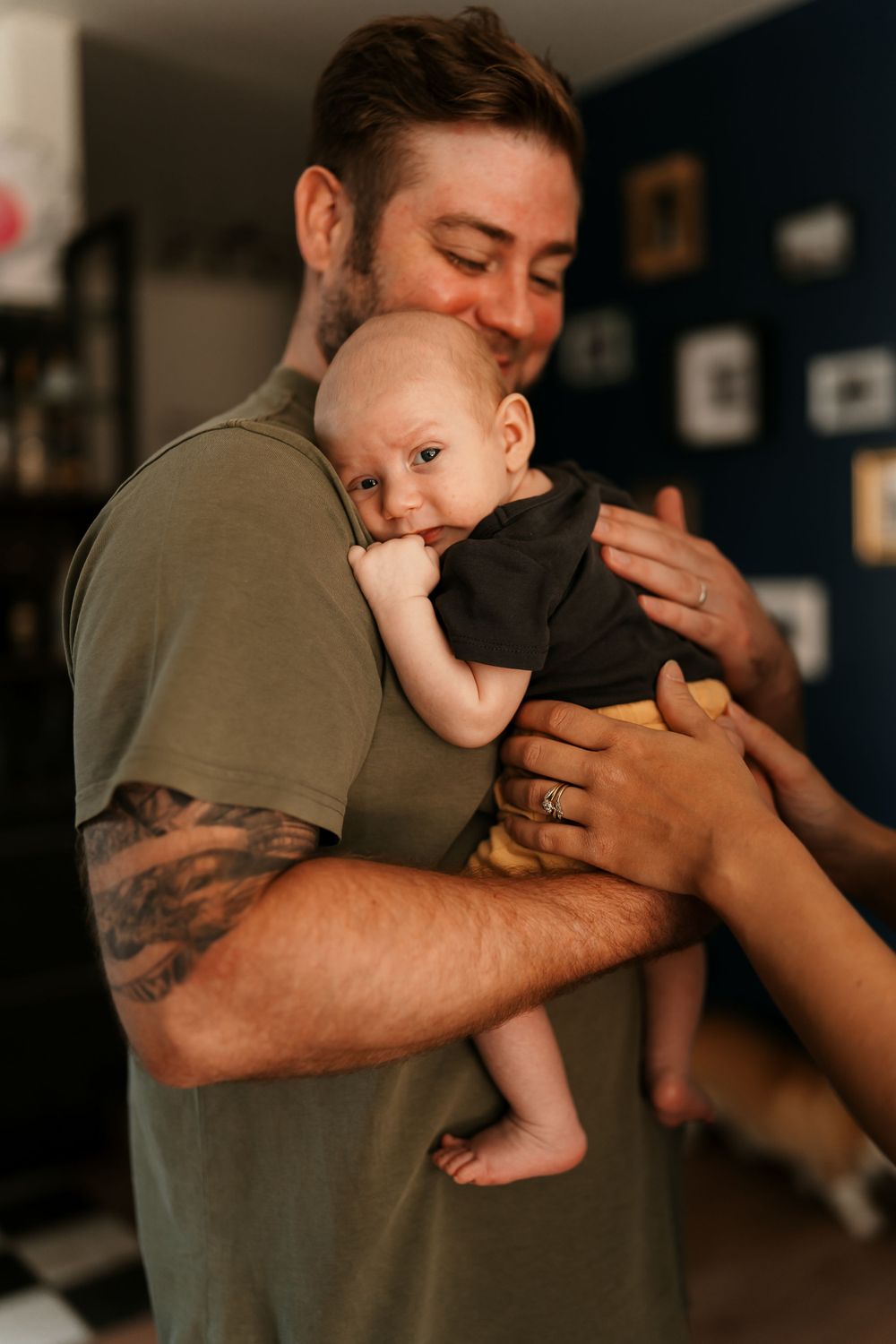 Gentle embrace between parent and infant in casual home setting.