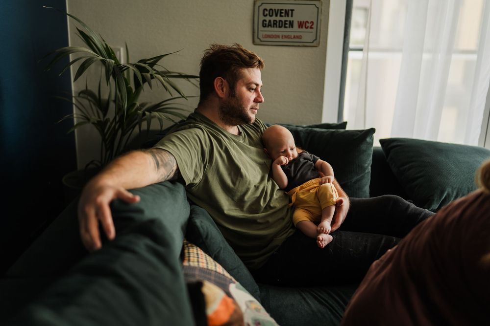A relaxed afternoon scene on a comfortable dark couch with natural light streaming in.