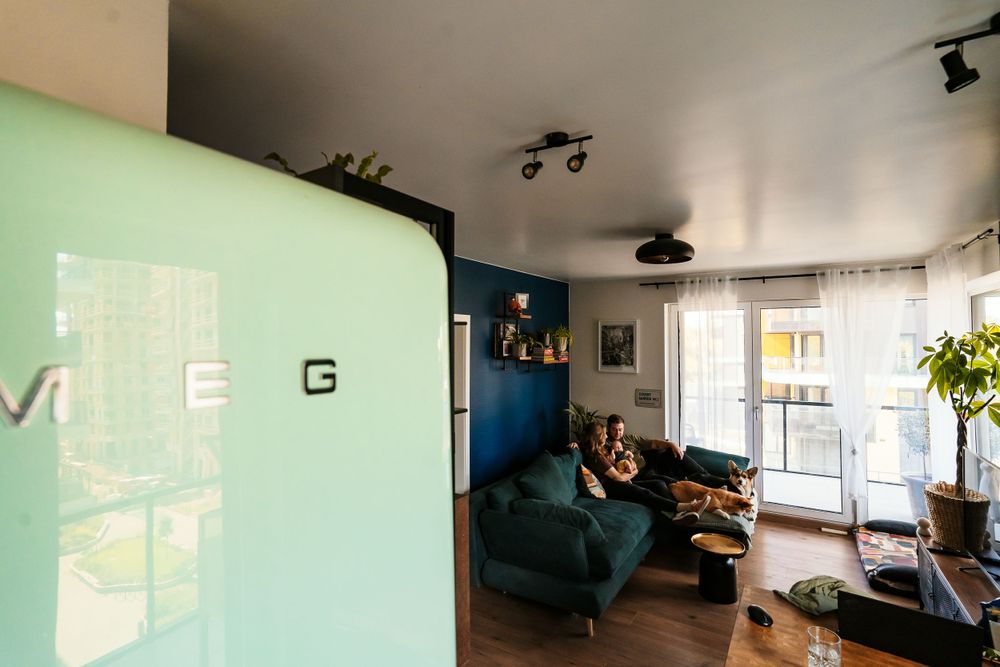 A cozy living room interior with a mint green wall, blue accent wall, and modern furniture.