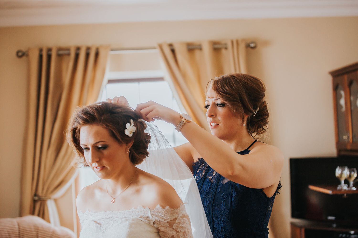 Wedding preparation scene with elegant drapes and natural window lighting.
