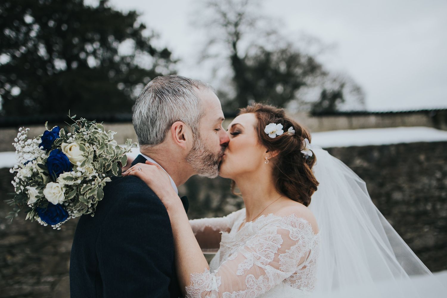 Romantic close-up shots of newlyweds embracing during their winter wedding celebration.