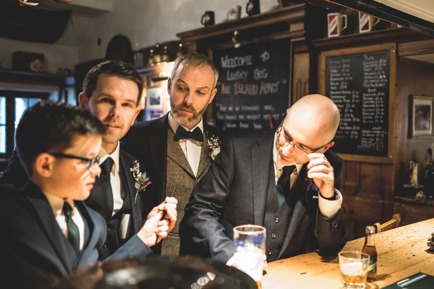 Friends enjoy drinks and conversations at a pub with chalkboard menus visible in the background.