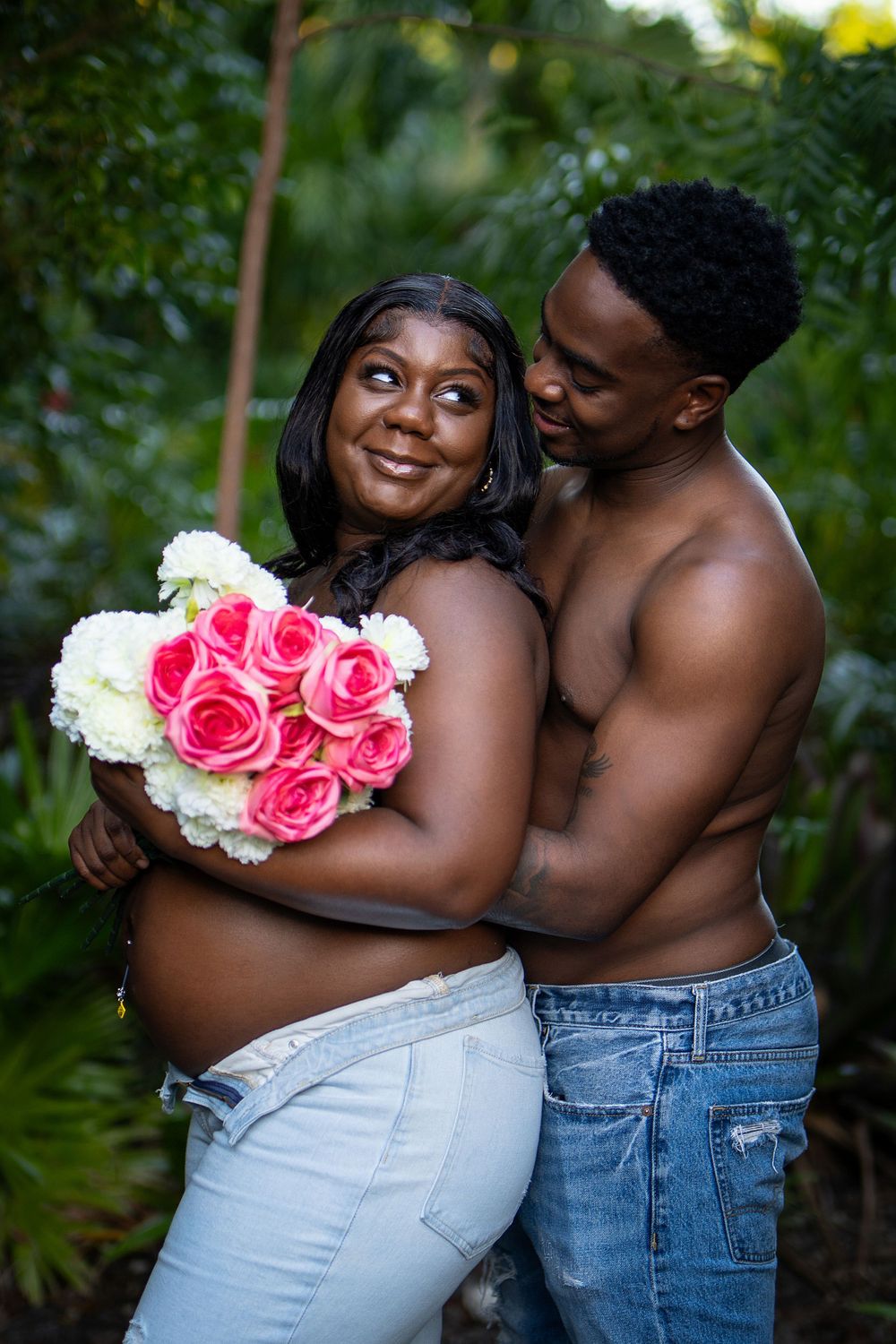 Woman with pink flowers posing among greenery — tropical lifestyle portrait by Timoy B Photography in Antigua.