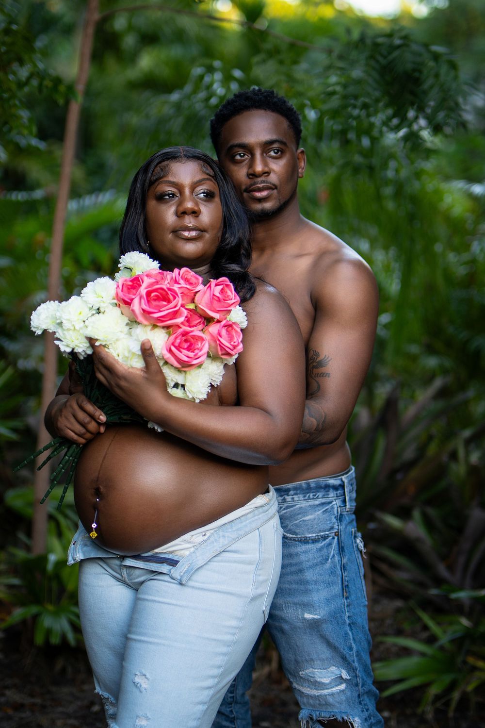 Couple embracing outdoors with flowers — intimate portrait session by Timoy B Photography.