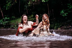 Playful water photoshoot with splashing and laughter in natural stream.