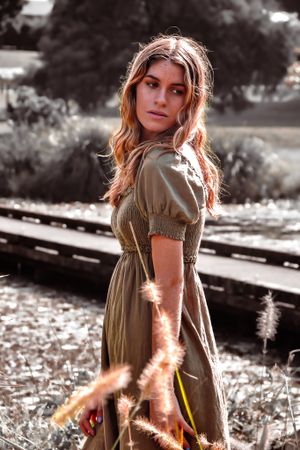 Sunlit portrait series in olive dress with vintage film aesthetic.