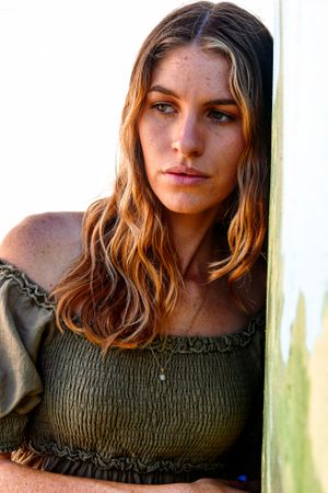 Close-up portrait series in natural light with olive peasant top.