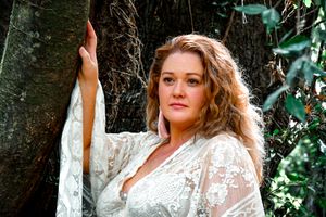 A dreamy outdoor portrait in white lace against lush greenery.