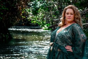 Moody outdoor fashion photography in emerald tones by water.