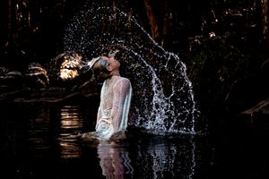 Water splashing dramatically in dark lighting creating abstract patterns.