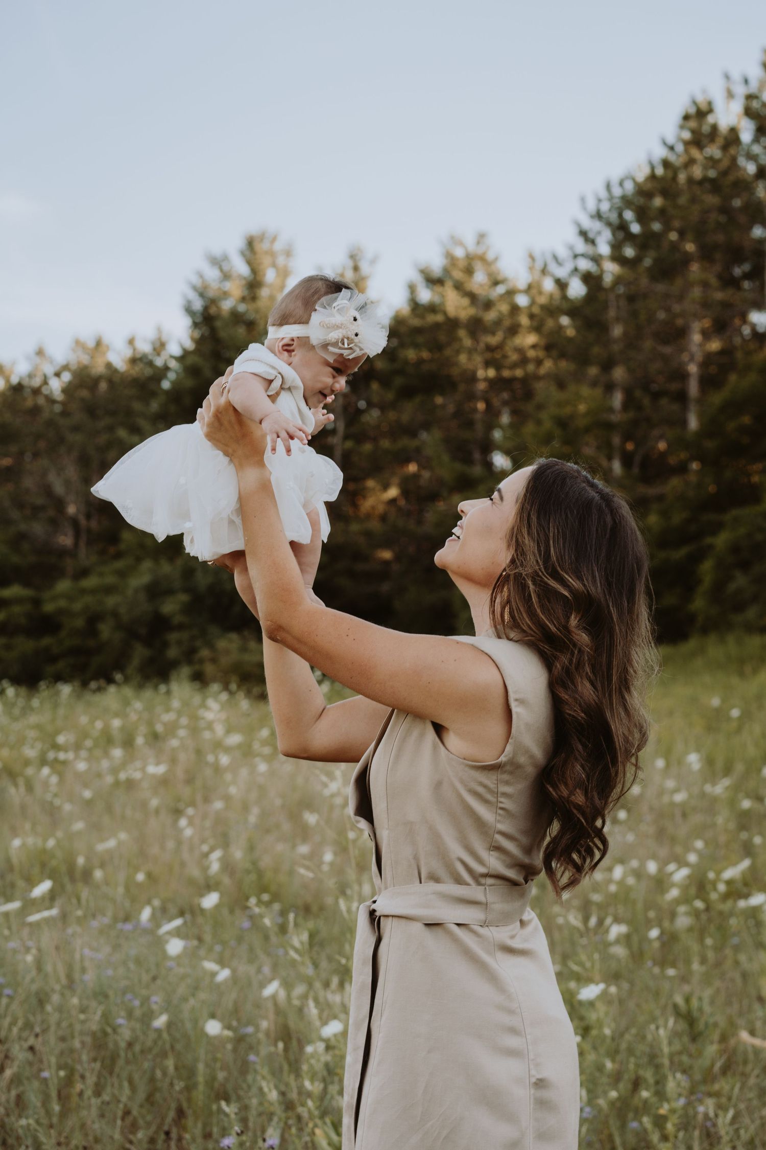 Image of woman holding up baby and smiling.