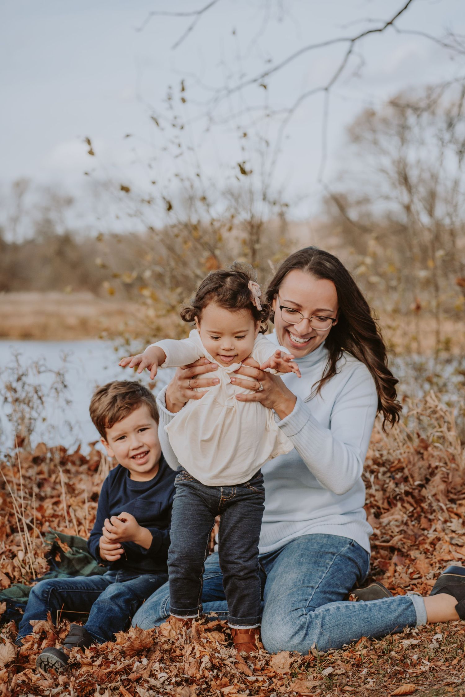 Image of mom and children in front of water.