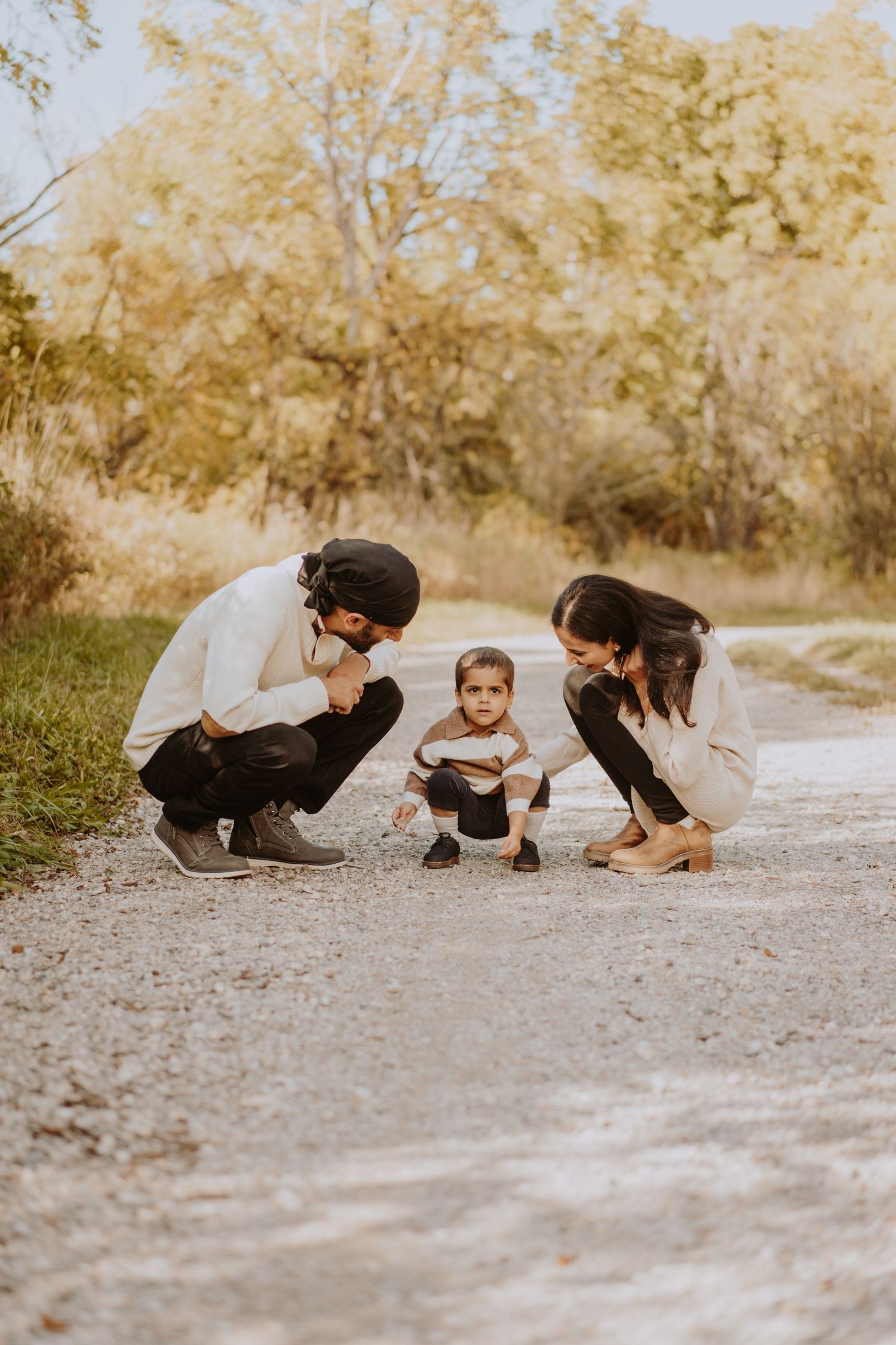 Image of couple crouching down looking at son.